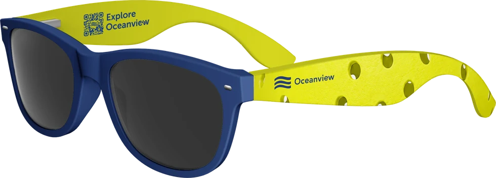Oceanview's pair as it was produced: navy frame, ball-yellow arms printed with a pickleball-hole pattern, the Oceanview logo by the hinge and an Explore Oceanview QR code inside the far arm.